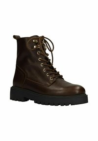 Bruine leren enkellaars met een gestructureerde afwerking, ronde neus en rubberen zool. Voorzien van metalen veterogen, vetersluiting en een aantreklipje.