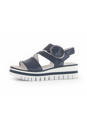 Navy leather sandal featuring cross straps, circular accent, and a thick white sole with navy accent stripes and a textured bottom.