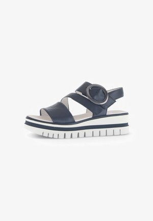 Navy leather sandal featuring cross straps, circular accent, and a thick white sole with navy accent stripes and a textured bottom.