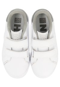 Zapatillas blancas con correas de Velcro, parte superior sintética texturizada, forro gris y marca en la plantilla y la lengüeta. Diseño de punta redondeada.