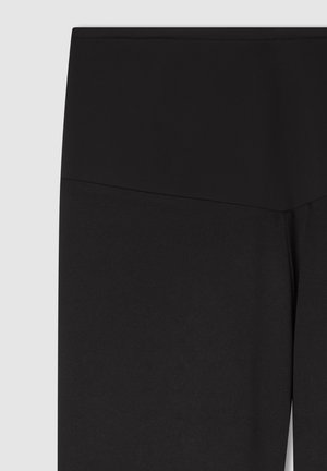 Leggings nere a vita alta in tessuto liscio e elasticizzato, con una vita senza cuciture e senza motivi o accessori visibili.