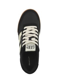 Deportivas negras con rayas blancas, punta redonda, diseño de cordones y suela de goma. Presenta un logo de GANT en la lengüeta y en el costado.