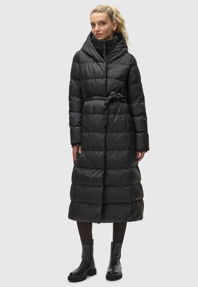 Zwarte pufferjas met een taille die is aangetrokken, een capuchon en lange mouwen. Heeft een geborduurd ontwerp en een riemdetail op de taille.