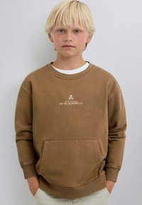 Braunes Sweatshirt mit Rundhalsausschnitt, langen Ärmeln und Fronttasche. Verfügt über ein aufgedrucktes Logo in hellbeige. Das Material wirkt weich und strukturiert.