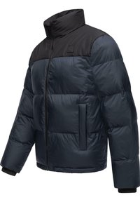 Jūras zilas pūdera jaka ar melnu augšējo daļu, augstu apkakli, priekšējo rāvējslēdzēju un elastīgām aprocēm; tai ir sānu kabata un piešūta tekstūra.