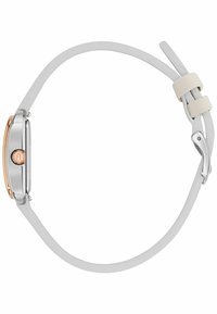 Montre argentée avec un boîtier rectangulaire, accents en or rose, bracelet en caoutchouc blanc et un design minimaliste avec un bouton sur le côté.