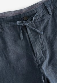 Pantaloni corti in lino blu scuro caratterizzati da una chiusura con bottone frontale, vita con cordoncino e una sottile trama con dettagli di cucitura visibili.