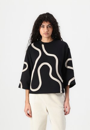 Black sweatshirt with oversized sleeves and beige wavy line patterns. Features a crew neckline and textured detailing on the designs.