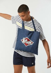 Denim-Umhängetasche mit blauer Stoff, doppelten Schulterträgern und einem auffälligen roten und weißen "Lee Cooper"-Logo in Form eines Diamanten.