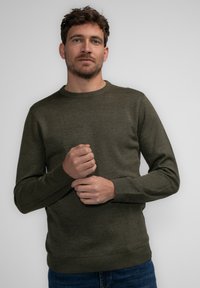 Olijfgroene crew-neck trui van zacht materiaal. Beschikt over lange mouwen, geribde boorden en zoom, met een getailleerde silhouet.