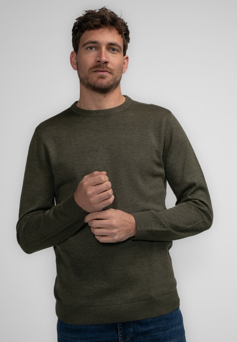 Olijfgroene crew-neck trui van zacht materiaal. Beschikt over lange mouwen, geribde boorden en zoom, met een getailleerde silhouet.