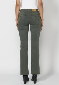 Koroshi BELL  - Šiek tiek platėjantys apačioje džinsai - kaki   khaki