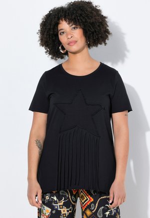 T-shirt noir à manches courtes avec un design d'étoile texturé et des accents à franges en bas. Fabriqué en tissu doux et extensible.