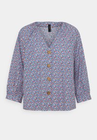 Blouse fleurie bleue, avec un col en V, des manches trois-quarts et des boutons en bois. Le tissu présente un petit motif floral multicolore.