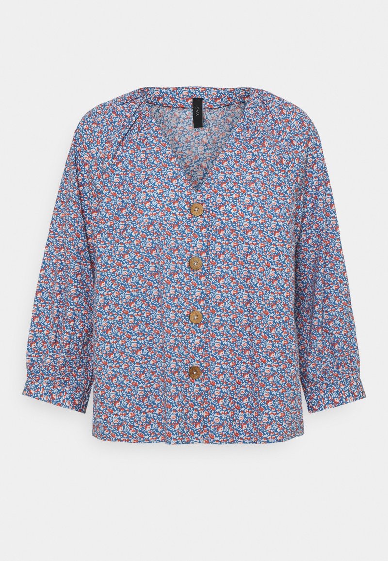 Blouse fleurie bleue, avec un col en V, des manches trois-quarts et des boutons en bois. Le tissu présente un petit motif floral multicolore.