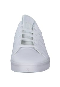 White sneakers with a smooth leather upper, rounded toe, and six-eyelet lace-up closure. Features textured accents on the sides and a flat rubber sole.