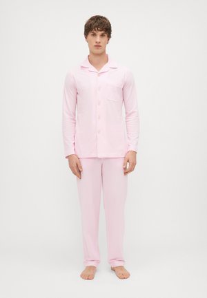 Világos rózsaszín pizsama szett, puha anyagból készült. Hosszú ujjú ing gombokkal és zsebbel; hozzá illő nadrág. Egyszerű, kényelmes dizájn.