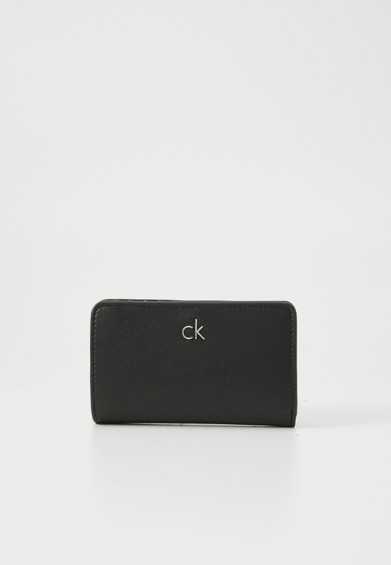 Black wallet made of smooth leather featuring a stitched edge and a silver "ck" logo on the front. Rectangular shape, compact design.