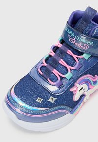 Niebieski materiałowy sneakers z wysoką cholewką, z błyszczącym wykończeniem, różowymi akcentami, irydyscencyjnymi detalami i wzorem jednorożca na boku. Posiada elastyczne sznurowadła.