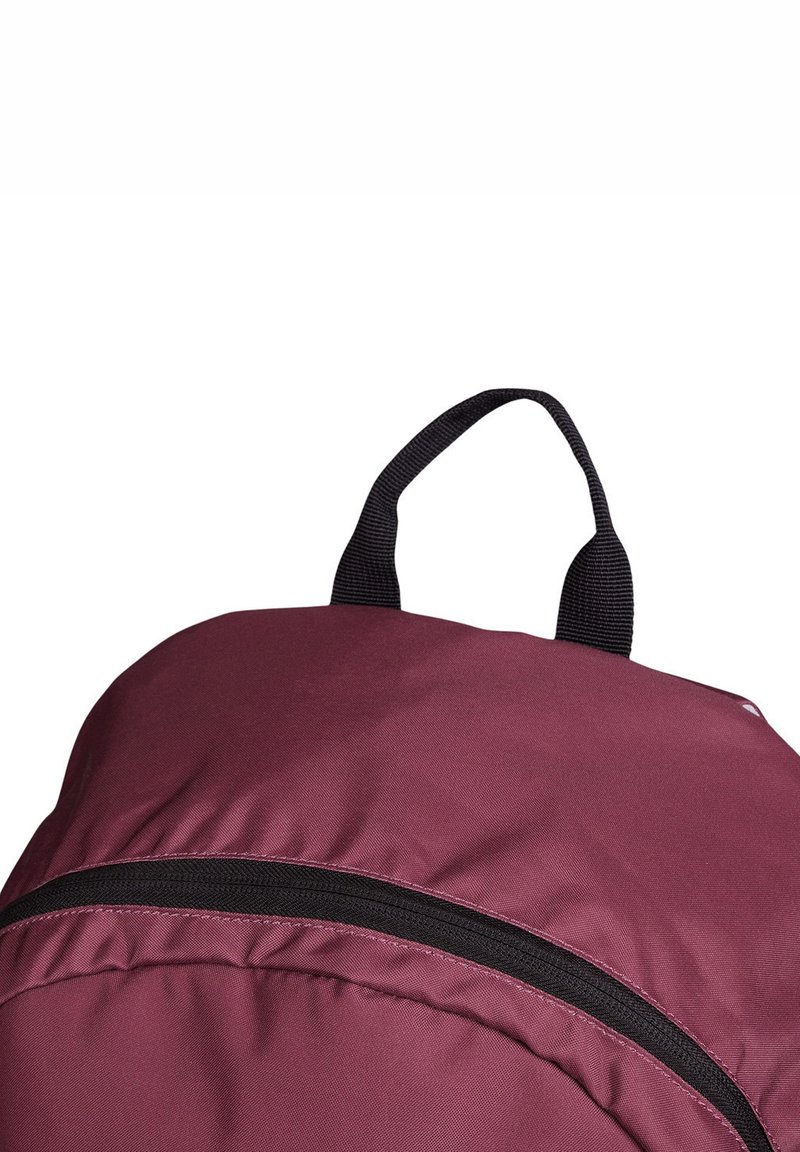 Burgunderroter Rucksack mit abgerundeter Form, aus Nylonmaterial, schwarzem Reißverschluss und einem Tragegriff oben. Glatte Oberfläche ohne auffällige Muster.