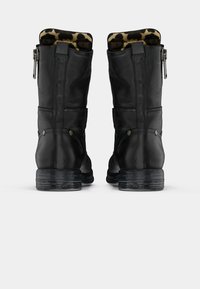 Black leather boots with a zip closure and a leopard print lining. Rounded toe and textured sole with a stacked heel design.