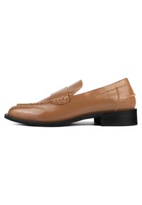 Tan leather loafers with a braided accent across the vamp and a low black block heel, featuring a smooth finish and rounded toe design.