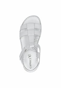 Bílé sandály s kříženými pásky, perforovanou stélkou a nastavitelným páskem kolem kotníku. Hladký ko žený povrch s jemným polstrováním.