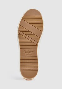 Suela de zapato de goma marrón con patrones de agarre texturizados, con un borde blanco y el logotipo de la marca en relieve "Pepe Jeans London."