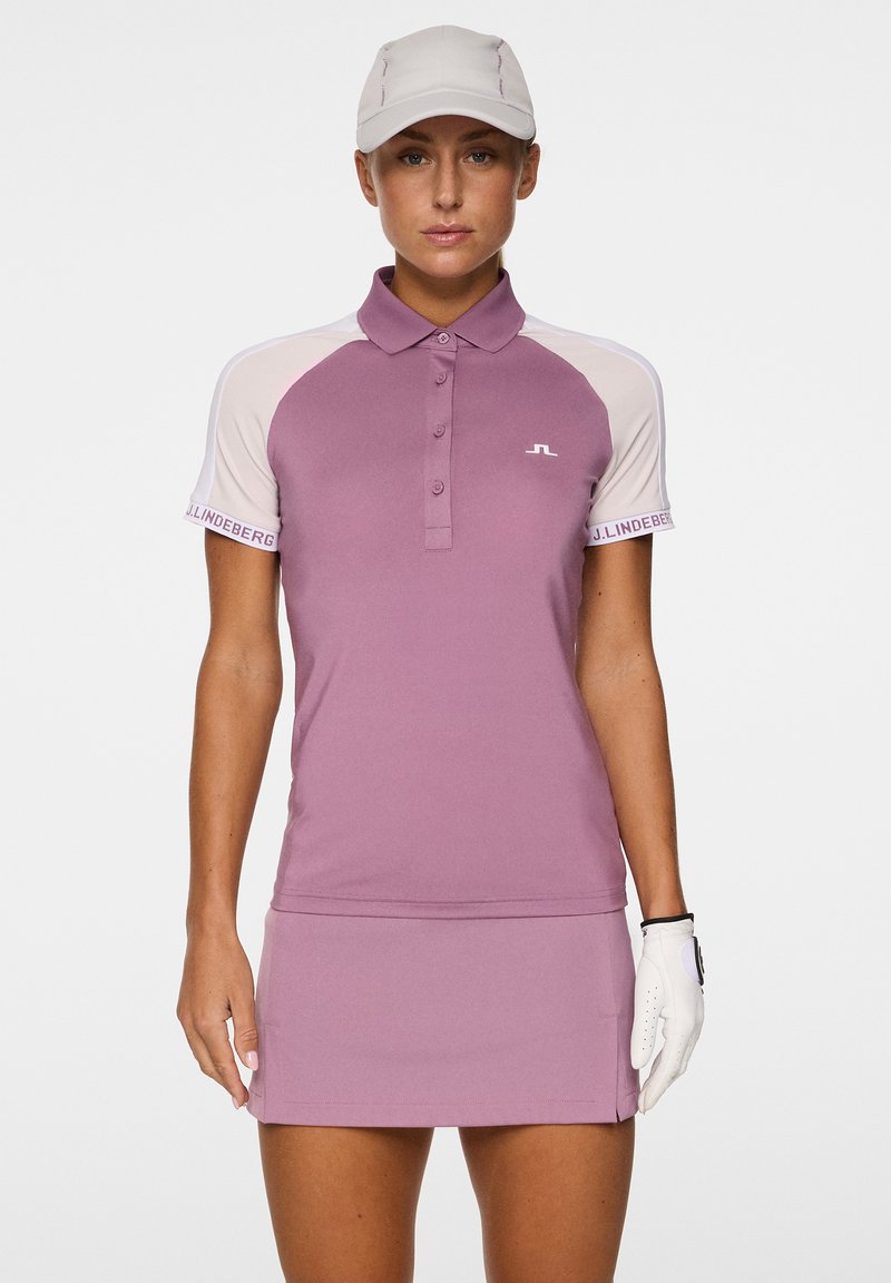 Polo a maniche corte per golf di colore viola chiaro con corpo uniforme e maniche a contrasto beige. Dotato di colletto e logo JL sul petto.