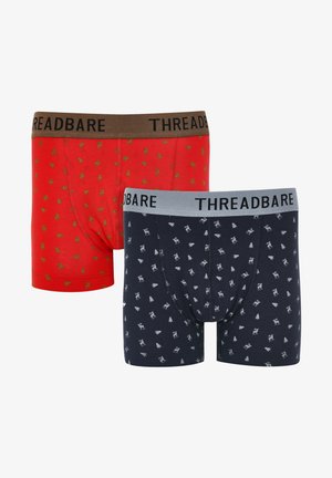 Rote und marineblaue Boxershorts mit grünen und weißen, holiday-inspirierten Mustern von Bäumen und Rentieren. Elastische Taillengummis in Braun und Grau.