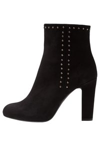 Botas de tobillo de ante negro con punta afilada, un tacón bloque alto y tachuelas metálicas dispuestas en filas verticales en el lado exterior.
