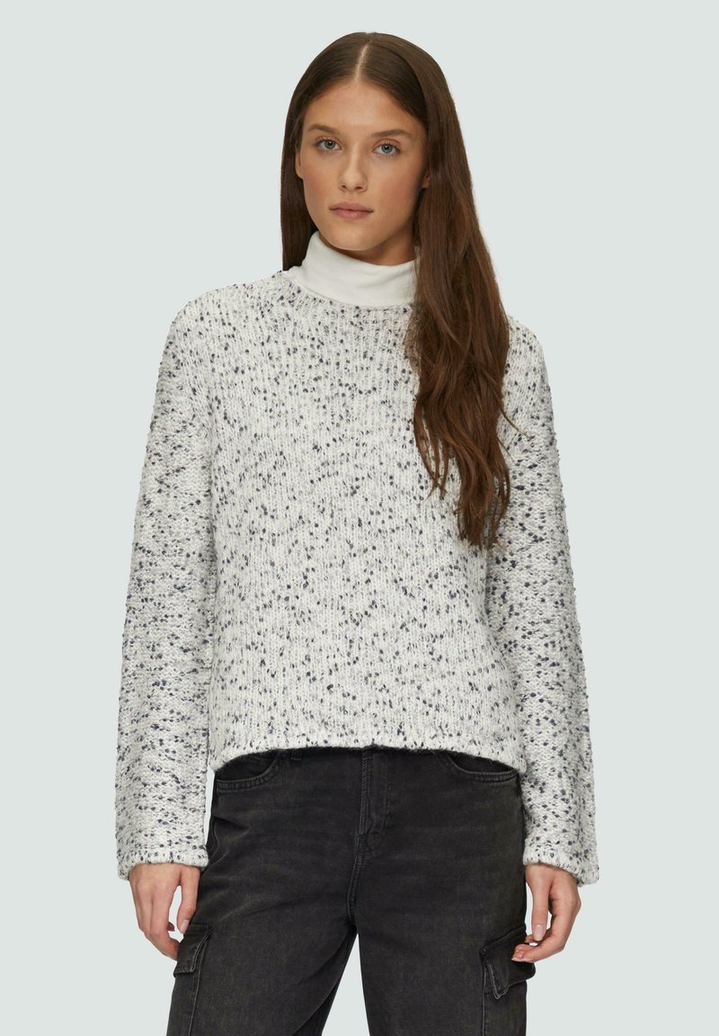 Pull en maille épaisse blanc avec des éclats gris, doté d'un col rond et de manches longues. Tissu texturé avec une coupe décontractée.