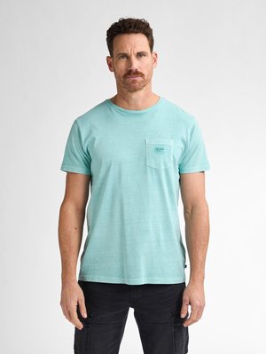 Light turquoise cotton t-shirt with a round neck, short sleeves, and a front pocket featuring a small label. Smooth texture, casual fit.