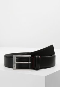 Cinturón de cuero negro con una textura suave, hebilla rectangular de plata y detalle de costura roja a lo largo del borde. Diseño plano, estética moderna.