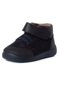 Zapato para niño pequeño en color azul marino, con parte superior de ante y sintético, que presenta una correa de gancho y bucle, un cuello acolchado y una suela de goma con textura.