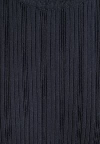 Tissu en tricot côtelé bleu marine foncé avec des rayures texturées verticales et un bord d'encolure ronde visible en haut.