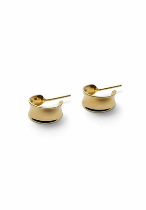 Pair of small, curved, shiny gold hoop earrings with post backs resting on a white surface.