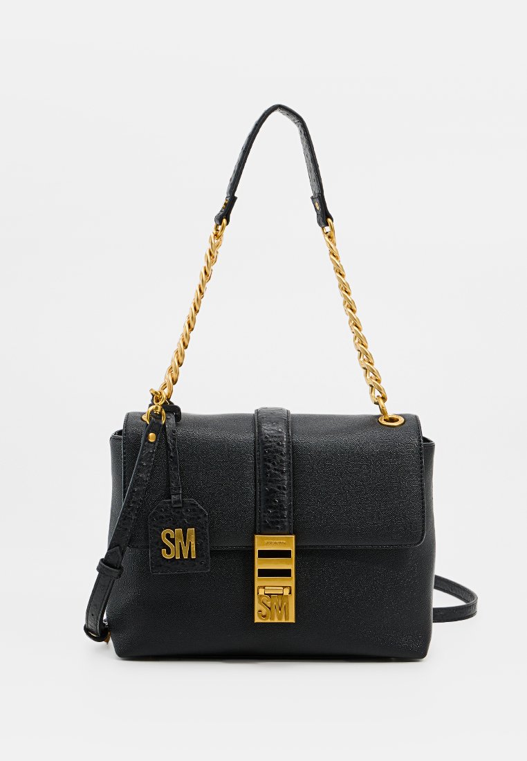 Zwart leren handtas met gouden kettingriem, gouden sluiting met "SM" initialen, en bijpassend leren label met "SM" initialen eraan bevestigd.