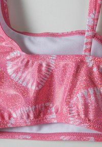 Cropped top rosa in materiale scintillante, con un motivo di felce bianca. Progettato con scollatura a barchetta e spalline sottili regolabili.