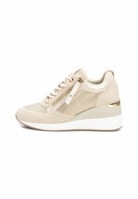 Zapatilla de ante beige con parte superior de malla, un sutil detalle de cremallera y una suela cuña blanca acentuada con herrajes dorados.