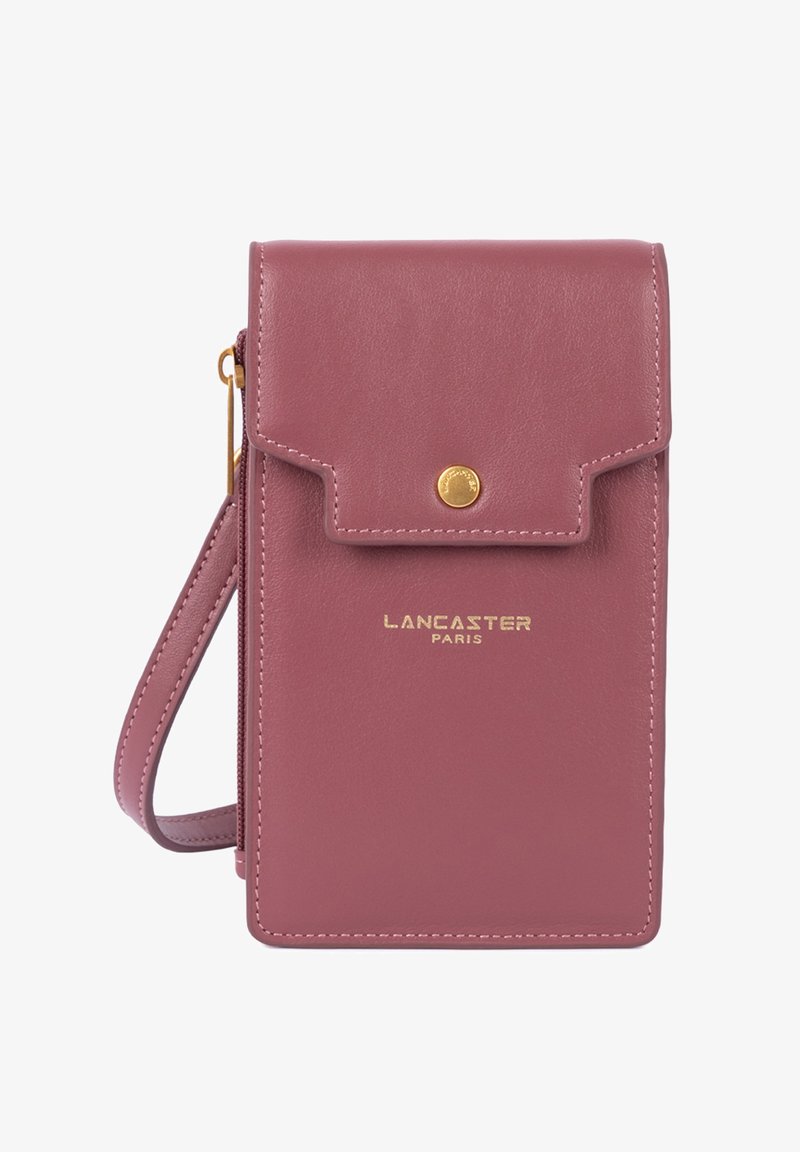 Pochette de téléphone en cuir rose avec une fermeture à rabat, des accessoires dorés et une bandoulière détachable. Présente un logo de marque embossé sur le devant.