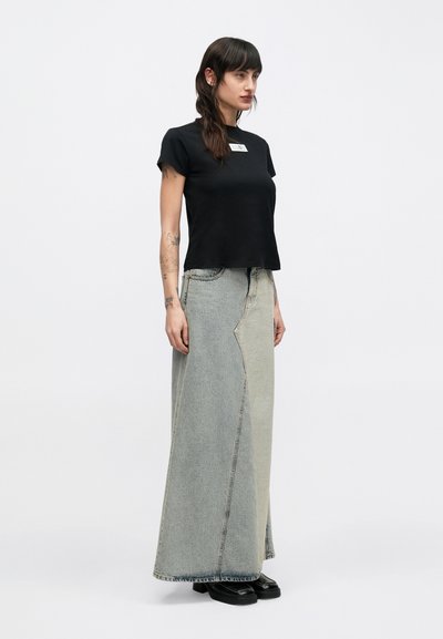 Zwart T-shirt met korte mouwen en een rechthoekige logopatch, gecombineerd met een lange denim rok in twee tinten, met een minimalistisch ontwerp en een rechte snit.