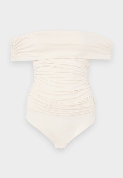 Μαγιό κρεμ απόχρωσης με off-the-shoulder σχεδίαση και ραφή, διαθέτει μαλακή υφή και κλείσιμο με κουμπί στο κάτω μέρος.