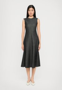 Hame tanpa lengan dengan panjang hingga lutut terbuat dari kain abu-abu gelap yang memiliki tekstur halus, menampilkan bodice yang pas dan desain rok yang melebar.