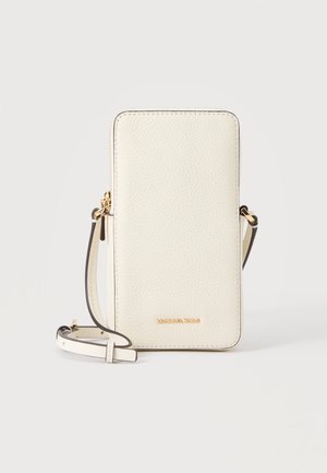 Sac téléphone bandoulière en cuir crème avec fermeture éclair dorée et logo, sangle réglable, surface texturée, posé debout sur fond blanc.