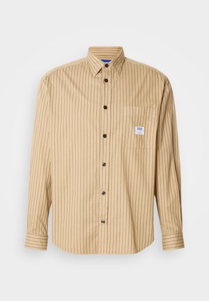 Camicia marrone chiaro con bottoni, righe verticali nere, colletto appuntito, tasca singola sul petto e bottoni neri. Realizzata in tessuto leggero.
