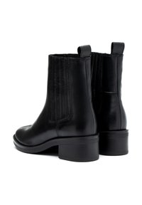 Bottes en cuir noir à chevilles avec un petit talon, présentant des panneaux verticaux sur les côtés et des languettes pour un enfilage facile. Texture lisse.