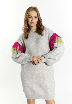 Graues gestricktes Kleid mit langen, puffigen Ärmeln und pinken sowie grünen Fransenakzenten an den Schultern. Gerippter Saum und Halsauschnitt.