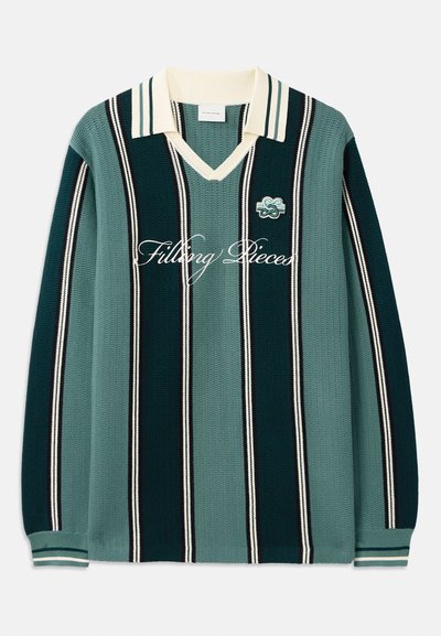 Strikket polo genser i mørkegrønt og teal striper, med hvit krage, lange ermer, og "Filling Pieces" brodert foran.
