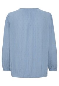 Helles blaues Blusenshirt mit gerafftem Rücken, langen Ärmeln und strukturiertem Stoff, der zarte erhabene Punkte zeigt. Gummizug an den Ärmeln und lockere Passform.